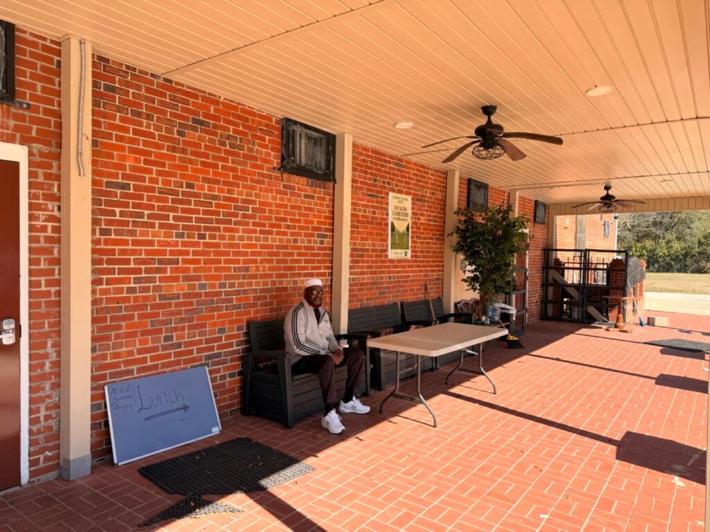 The covered brick breezeway with benches, ceiling fans and a hand-lettered sign